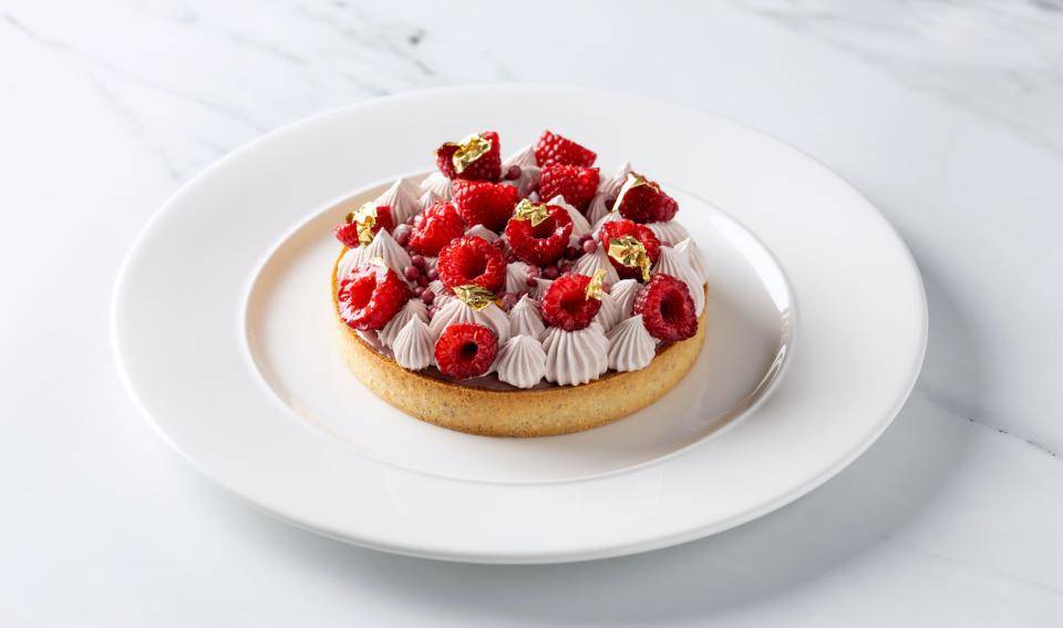 A tart wth ruby whipped ganache and raspberries