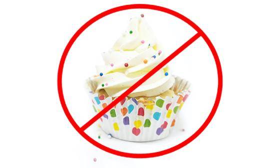 A red circle with a line through it superimposed over a cupcake